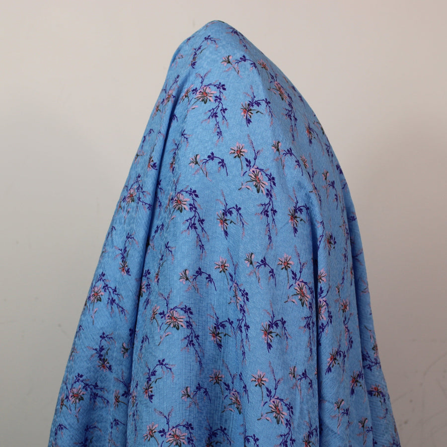Tissu crêpe  gaufré - imprimé fleuri - ton bleu ciel